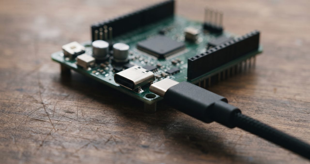 USBケーブルの先端がマイコンボードのUSBポートに差し込まれる直前の様子をクローズアップした物撮り写真